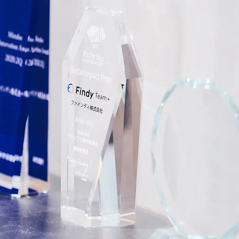 クリスタルのトロフィーに刻まれたRuby bizグランプリ2023のSocial Impact Prize受賞記念。Findy Team+（ファインディ株式会社）の受賞を記念する透明な楯